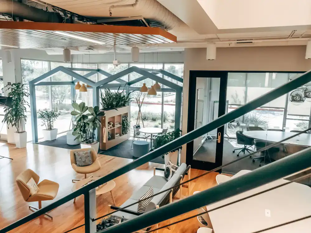 Bright open plan coworking area with natural light and plants